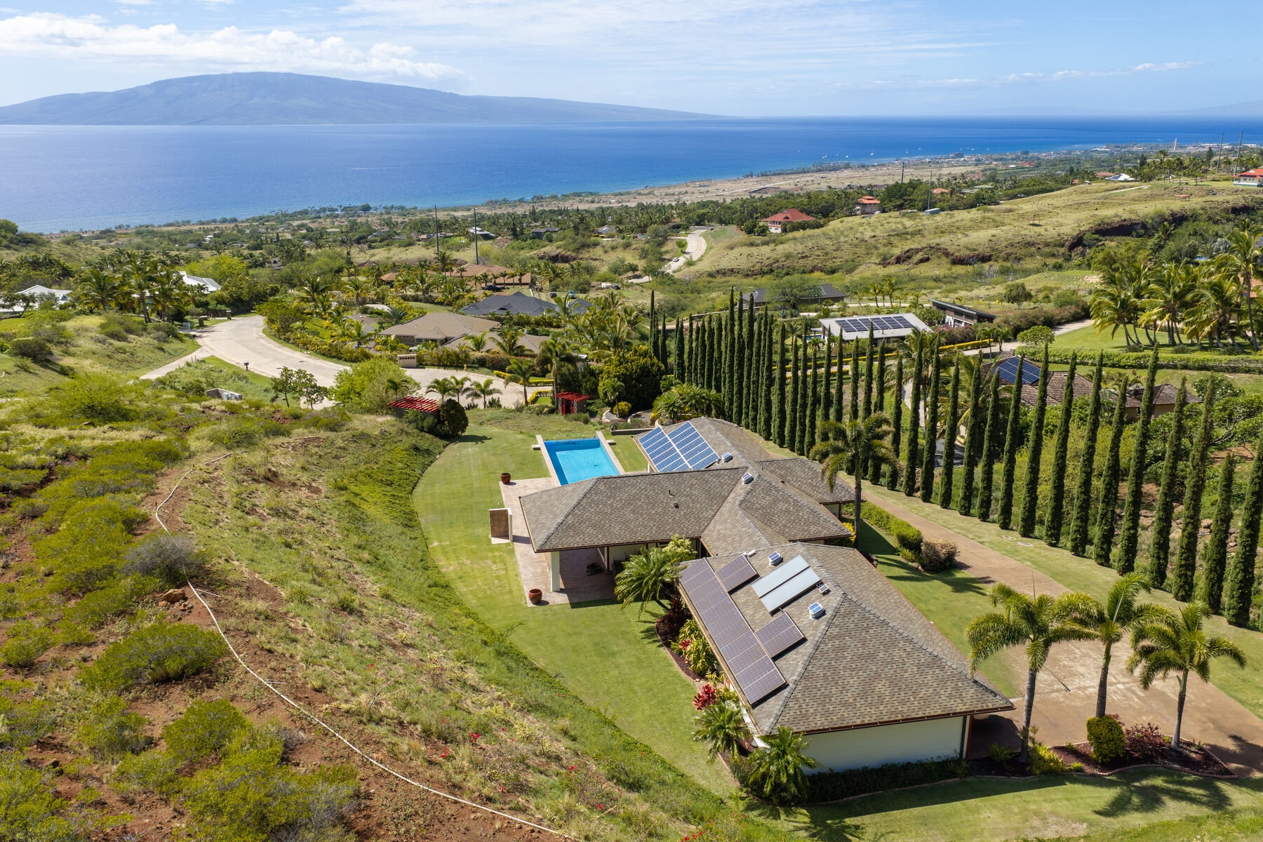 Aerial of the residence, cypress drive and acreage with the ocean and Lanai beyond