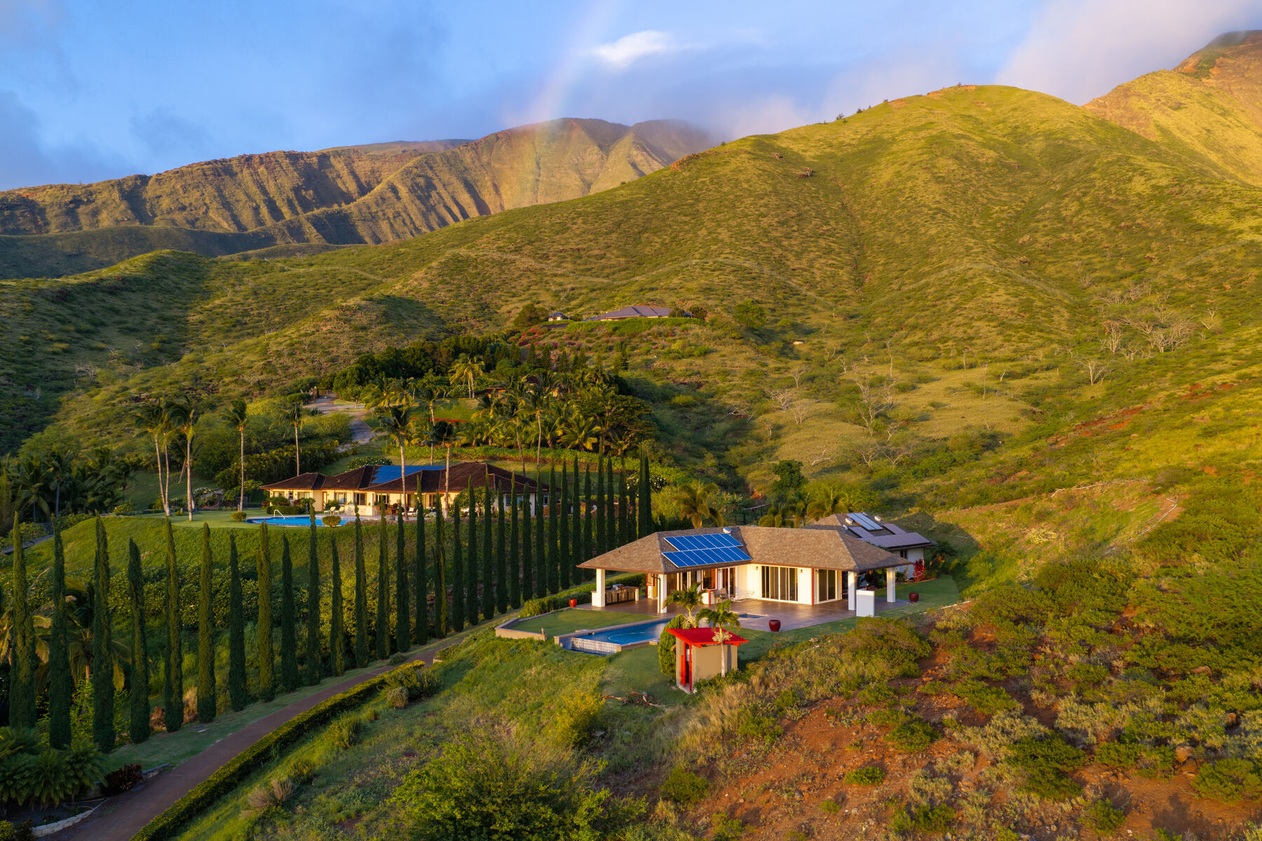 The residence in golden light beneath the West Maui Mountains