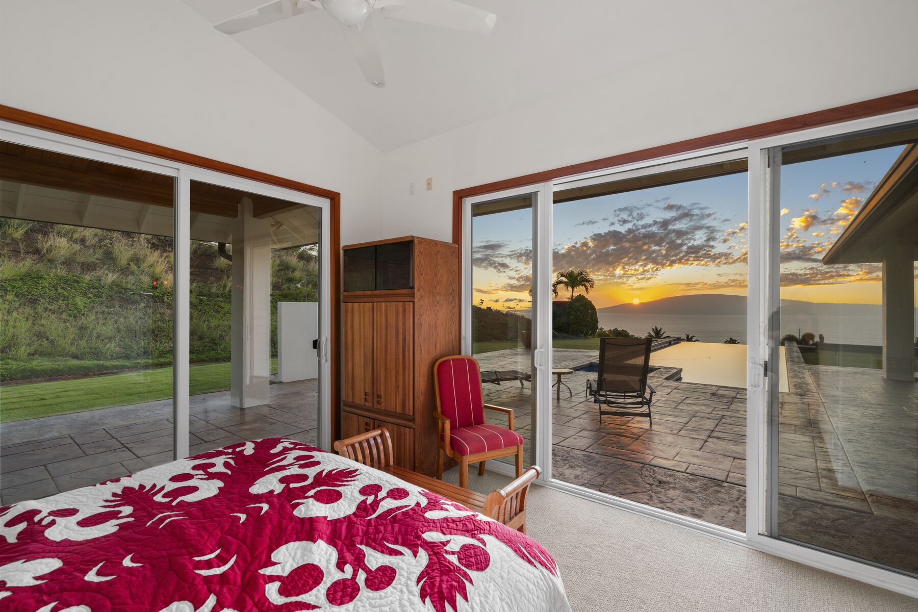 Primary bedroom opening to the pool at sunset